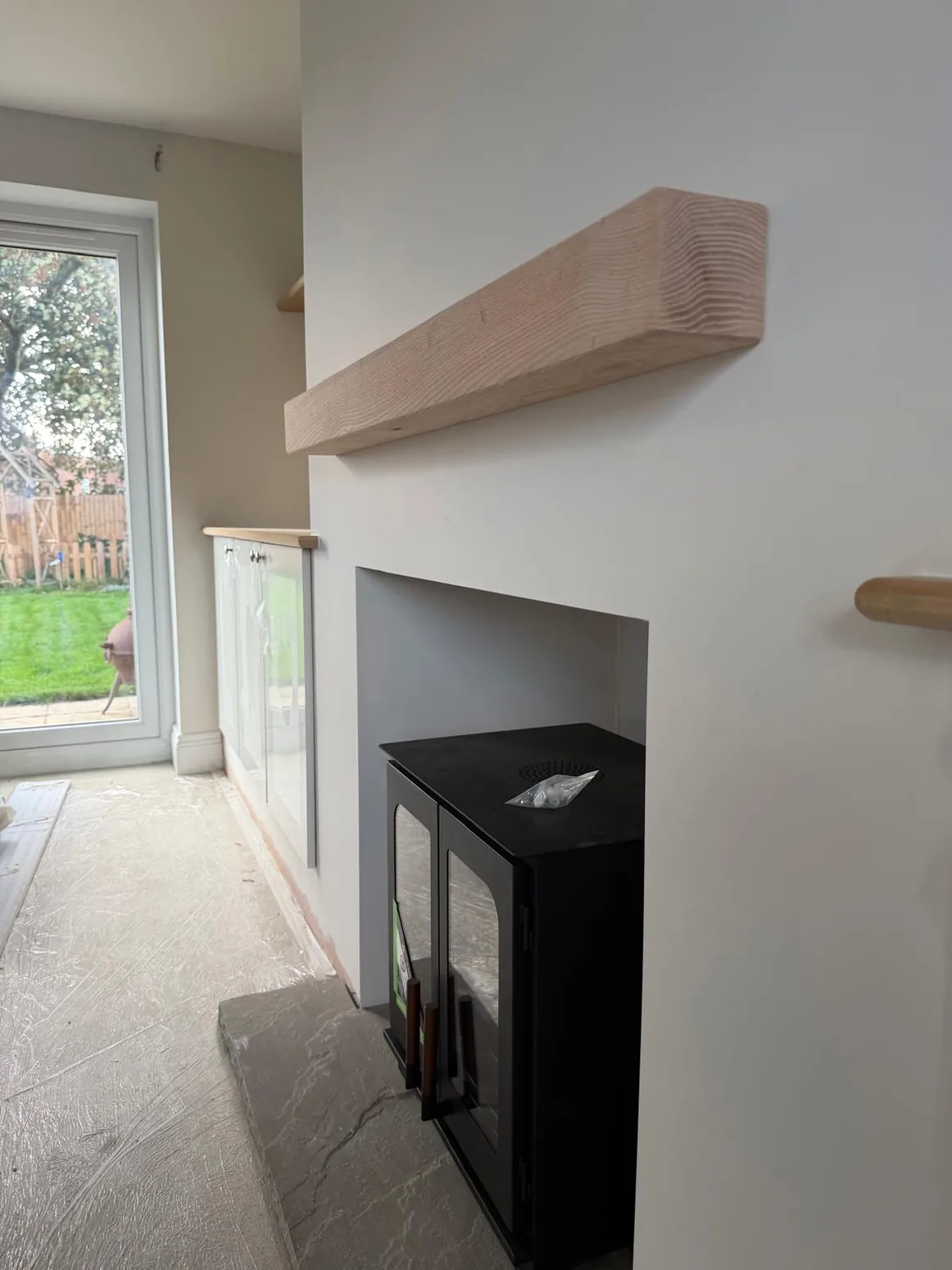 Neutral fitted living room storage and fireplace surround