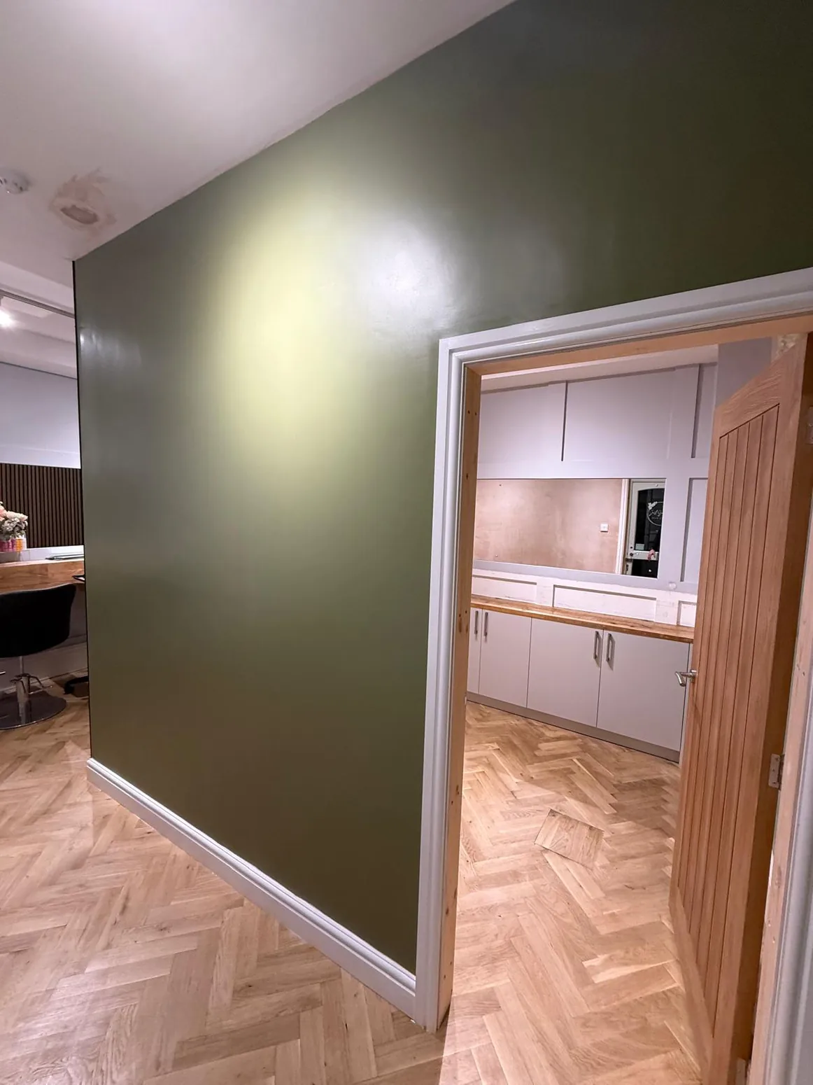 Green interior with crafted timber doorway and architrave