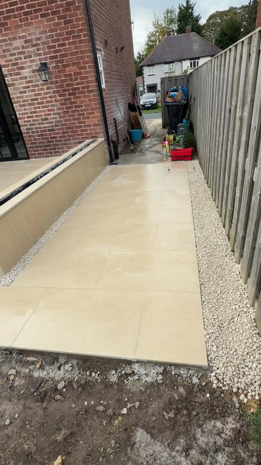 Natural-coloured porcelain paving laid alongside exterior wall